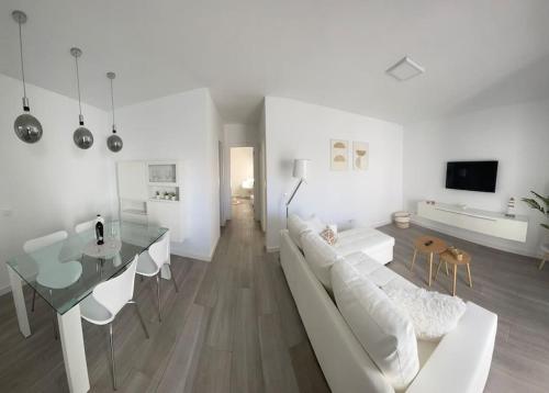 ein weißes Wohnzimmer mit einem weißen Sofa und einem Tisch in der Unterkunft White Serenity in Playa Honda