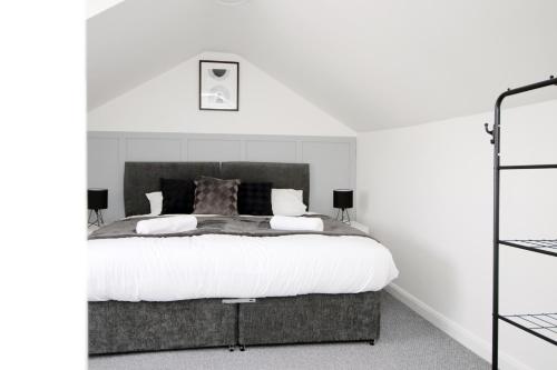 ein Schlafzimmer mit einem großen Bett mit weißen Wänden in der Unterkunft Entire 2 Bed Modern Flat with Parking For Families, Business and Contractors in Bristol