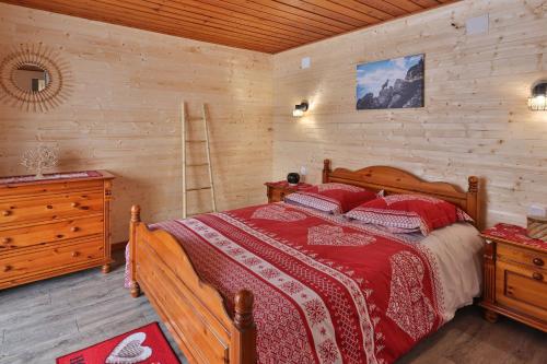 une chambre avec un lit et un mur en bois dans l'établissement Chalet au bois des écureuils classé trois étoiles., à Muhlbach-sur-Munster