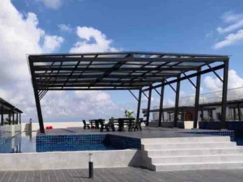 ein Pavillon mit Picknicktisch am Strand in der Unterkunft The Ximplicity @ Venus Residence Sitiawan Manjung in Sitiawan