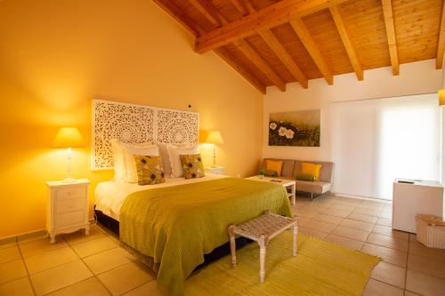 a bedroom with a bed with a green bedspread at Monte da Ameixa Country House in Castro Verde