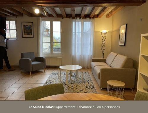 オセールにあるAppartement le Saint-Nicolas Auxerre Les Quaisのソファとテーブルのあるリビングルーム