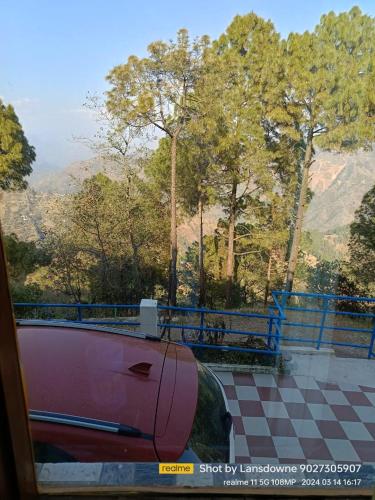 a pink car parked next to a blue fence at Joshi Holiday Home Stay in Lansdowne