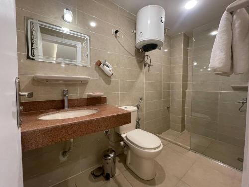 a bathroom with a toilet and a sink and a shower at Hotel Royal Plaza in Asyut