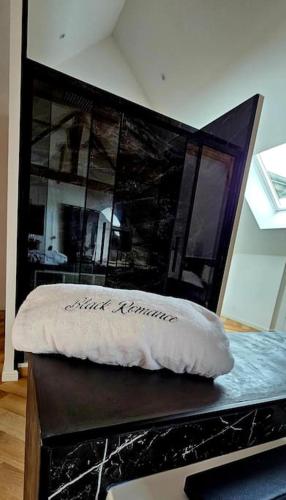 - un lit avec un oreiller dans l'établissement Black Romance, à Yville-sur-Seine