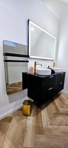ein Bad mit einem Waschbecken und einem Spiegel in der Unterkunft Black Romance in Yville-sur-Seine