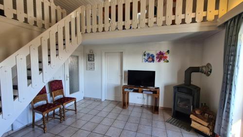 a living room with a staircase and a wood stove at Ferienhaus-Zandt in Zandt