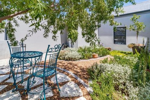 d'une terrasse avec une table et des chaises dans le jardin. dans l'établissement Stunning 3 Bedroom Apartment on Turfhall, au Cap