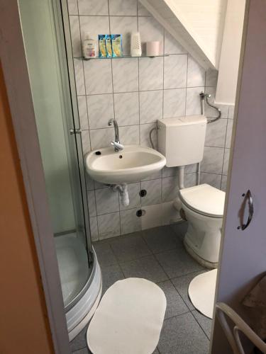 a small bathroom with a sink and a toilet at Sashalom Hotel in Budapest