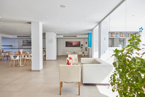 a lobby with white furniture and tables and chairs at Hotel Ilusion Calma & Spa in Can Pastilla