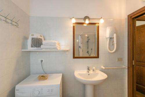 Baño blanco con lavabo y espejo en il Nazareno - Il Coppaio, en Cecina