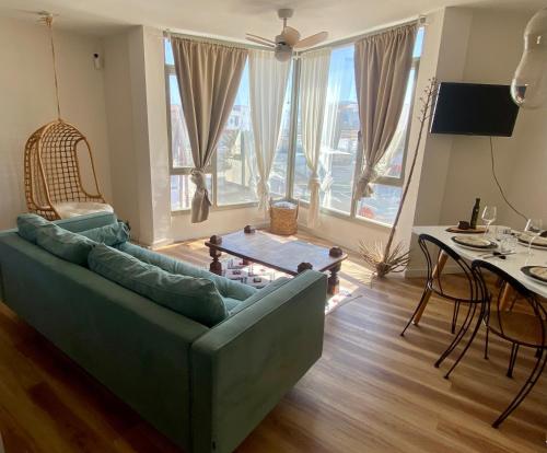 ein Wohnzimmer mit einem grünen Sofa und einem Tisch in der Unterkunft Casa Tela Marinera in Cotillo