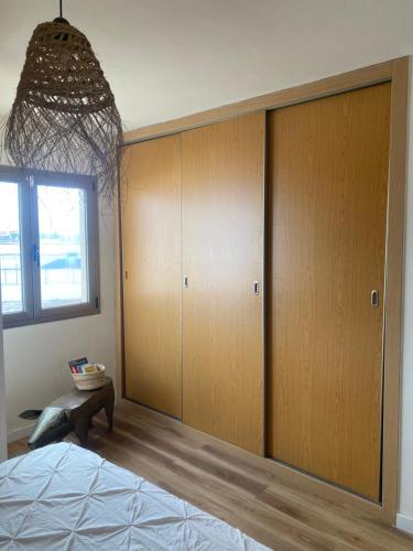 科提約的住宿－Casa Tela Marinera，一间卧室设有木制橱柜、一张床和一个窗户。