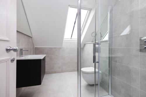 e bagno con servizi igienici e doccia in vetro. di Dragon Suites - City Centre Castle View 1 Bed Apartment a Edimburgo