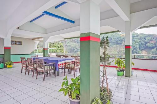 comedor con mesa azul y sillas en OYO 90132 Lie Mas Hotel en Pasuruan