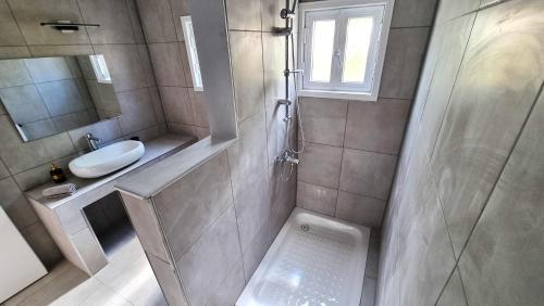 uma casa de banho com um chuveiro, um lavatório e um WC. em Center 2Br Apt w/ parking and 250m walk from beach em Lárnaca