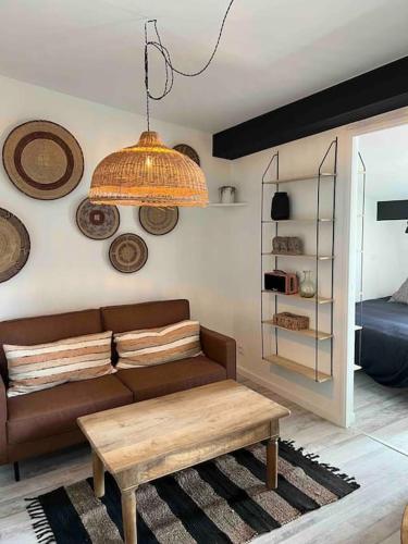 un salon avec un canapé marron et une table dans l'établissement Le passage 75, à Montpellier