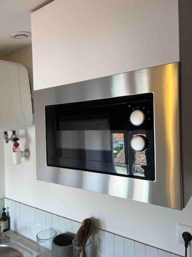 - un four micro-ondes au-dessus d'un comptoir de cuisine dans l'établissement Le passage 75, à Montpellier