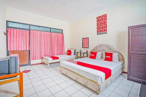 1 dormitorio con 2 camas y TV. en OYO 90132 Lie Mas Hotel en Pasuruan