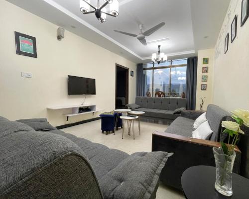 a living room with a couch and a tv at Danny Luxe Apartments in Islamabad
