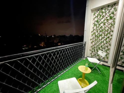 balcón con mesa, sillas y vistas en Danny Luxe Apartments en Islamabad