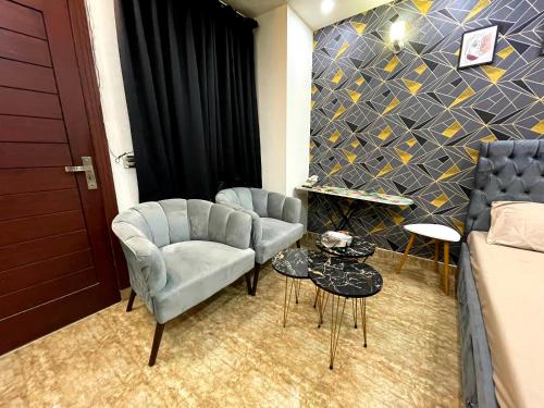 a room with two chairs and a couch and a table at Danny Luxe Apartments in Islamabad