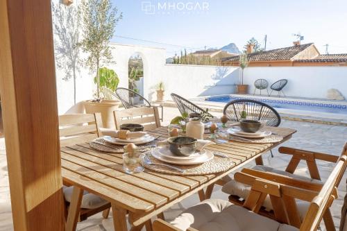 a wooden table with dishes on it on a patio at CASA LA MOTUCA - Calpe COSTA BLANCA in Calpe