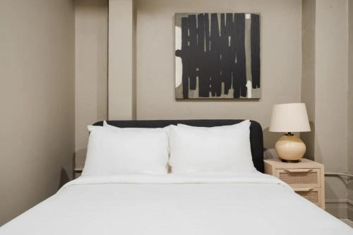 a bedroom with a large white bed and a lamp at La Luz in San Antonio