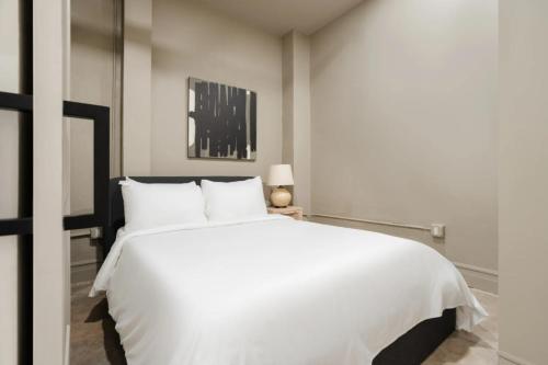 a bedroom with a large white bed with white pillows at La Luz in San Antonio