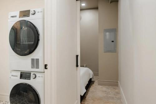 a laundry room with a washer and dryer next to a bed at La Luz in San Antonio