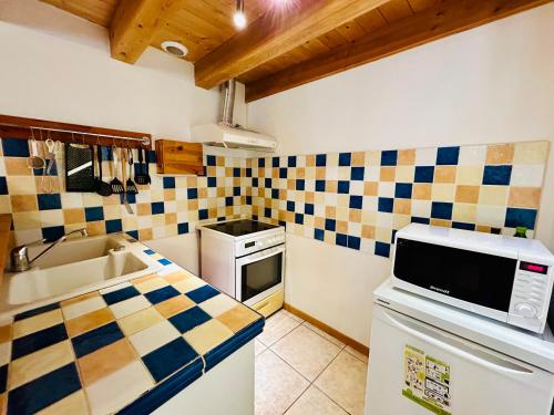a kitchen with checkered tiles on the wall at Au pied du château avec terrasse - CLG Savoie - 1Ch - 1SDB in Fréterive