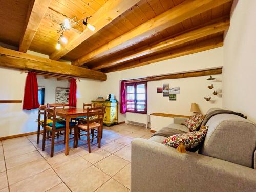 een woonkamer met een bank en een tafel bij Au pied du château avec terrasse - CLG Savoie - 1Ch - 1SDB in Fréterive
