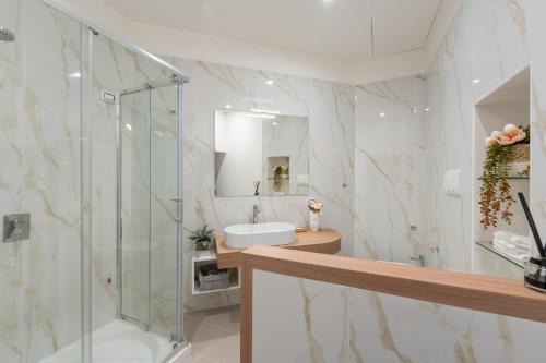 La salle de bains est pourvue d'une douche en verre et d'un lavabo. dans l'établissement Palazzo Della Porta B&B, à Naples