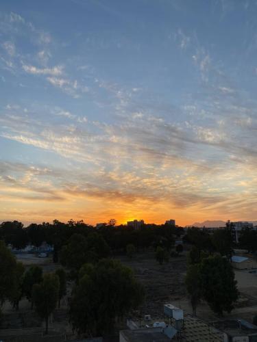 a sunset over a city with trees and buildings at Warm Residence in the heart of the City Center - Balcony & view in Nicosia