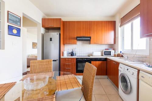 a kitchen with a glass table and a refrigerator at Warm Residence in the heart of the City Center - Balcony & view in Nicosia