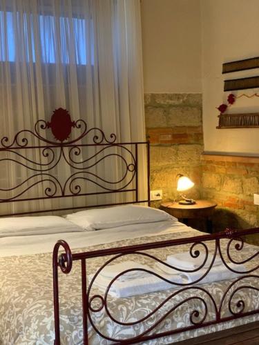 um quarto com uma cama de metal e uma janela em Agrisalotto em Cortona