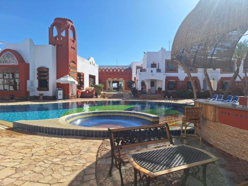 una piscina en un patio con un banco y edificios en Sharm Inn Amarein - Boutique Hotel en Sharm El Sheikh