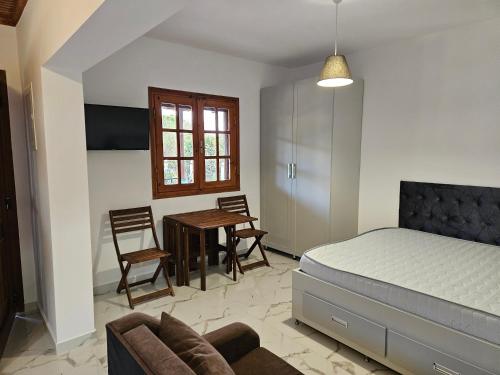 a bedroom with a bed and a table and chairs at Sandy Coast Apartments in Nea Kalikratia