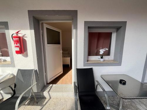 een kamer met een tafel en een raam met een brandblusser bij Pension Donau in Hannover
