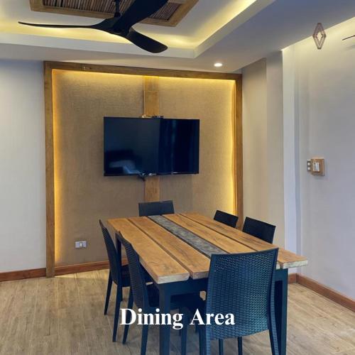 a dining area with a wooden table and chairs at Bugana Beach and Dive Resort in Manlocahoc