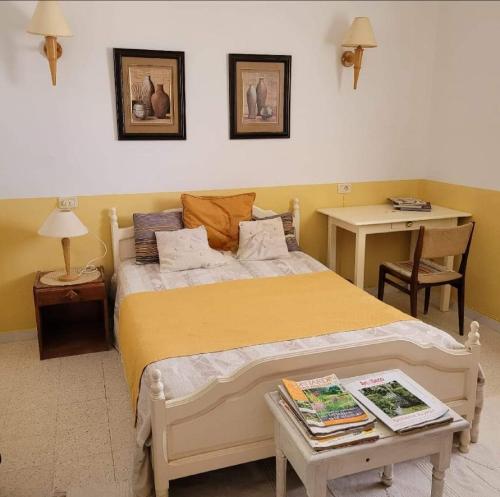 a bedroom with a large bed and a table at Djerba chambres d'hôtes in Houmt Souk