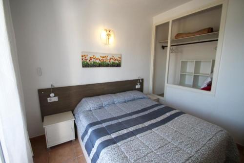 ミアミ・プラトーヤにあるCasas Blancas 12の小さなベッドルーム(ベッド1台、鏡付)