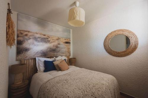 une chambre avec un lit avec un tableau sur le mur dans l'établissement La maison du pêcheur, à Palavas-les-Flots