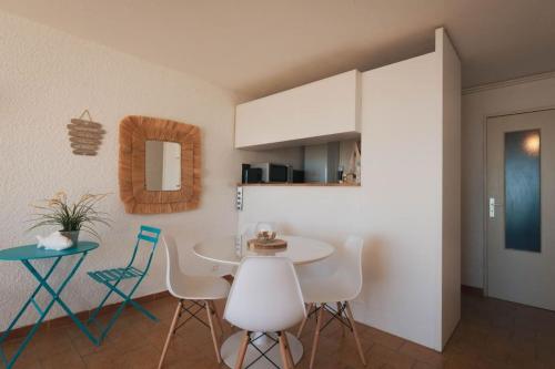 une salle à manger avec une table et des chaises blanches dans l'établissement La maison du pêcheur, à Palavas-les-Flots