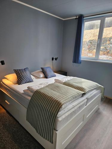 a large bed in a bedroom with a window at Apartment Isfjordsveien in Åndalsnes