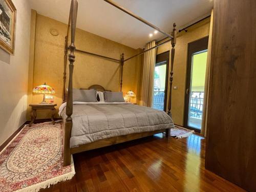 sypialnia z łóżkiem z baldachimem i drewnianą podłogą w obiekcie Mikpritja Korce 1 w mieście Korcza