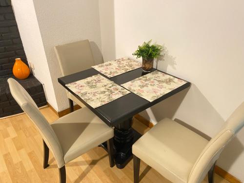 a black table with two chairs and a plant on it at Quetzal House in Tijuana