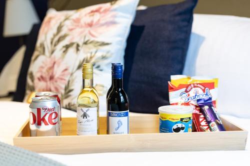 a wooden tray with two bottles of wine and snacks at Kingston House in Torquay