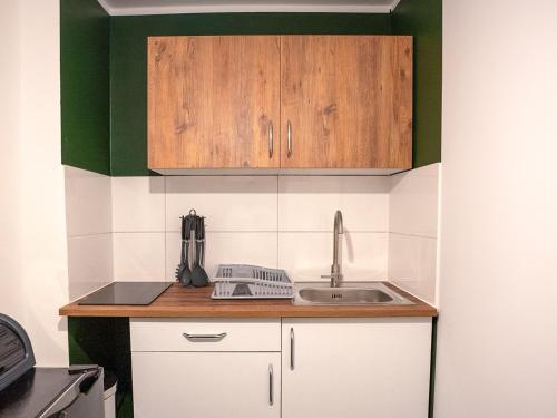 a kitchen with wooden cabinets and a sink at SR24 - Space in Oer-Erkenschwick in Oer-Erkenschwick