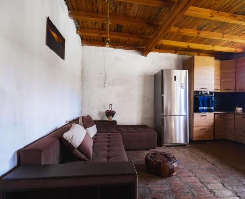 uma sala de estar com um sofá e um frigorífico em Вила "Намасте" с панорамна гледка и камина на дърва em Lovech